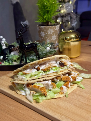 tortilla fitness z kurczakiem i sosem jogurtowym na talerzu