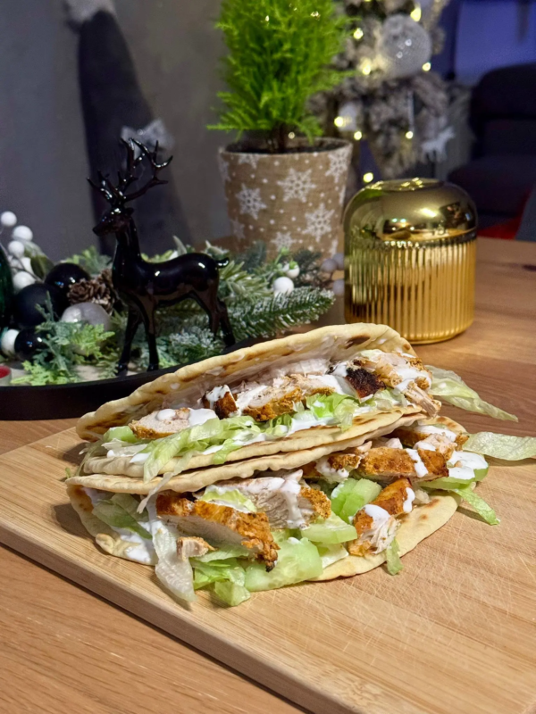 tortilla fitness z kurczakiem i sosem jogurtowym na talerzu